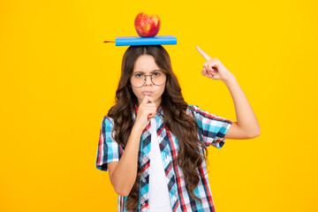 Canvas Print - Back to school. Teenager schoolgirl with apple on head, ready to learn. School children on isolated yellow background. Thinking pensive clever teenager girl.