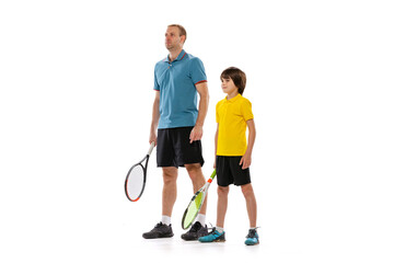 Professional tennis player, instructor and school age boy wearing sports uniform standing together isolated over white background. Concept of sport, achievements, hobby, skills