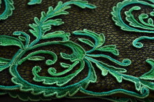 Green Pattern. Beautiful Knitted Elements On Black Mesh Background. Irish Lace.