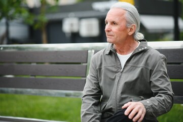 Wall Mural - Old gray-haired man rest on the bench in summer park