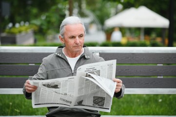 Wall Mural - Old gray-haired man rest on the bench in summer park