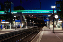 Front View Train Station In Switzerland At Night With No People. Illuminate The Scene Of Modern Street Lamps
