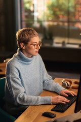 Poster - Vertical Screen: Young Attractive Woman Using Desktop Computer in Stylish Loft Apartment During the Day. Creative Female Checking Social Media, Browsing Internet, Wearing Cozy Clothes.