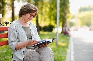 Sticker - Retired woman reading a book on the bench