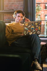 Aufkleber - Vertical Screen: Young Handsome Man Working from Home on Laptop Computer in Stylish Loft Apartment During the Day. Creative Person Checking Social Media, Browsing Internet.