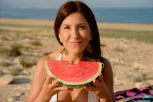 Woman Enjoy Eating A Watermelon Outdoors On The Beach