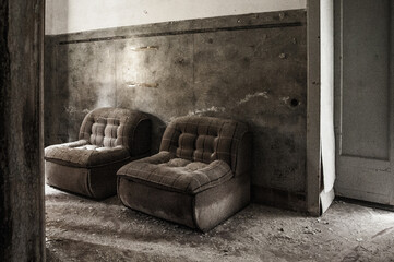 July 2022, Italy, Urbex. two old armchairs in an abandoned room