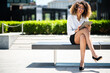 Smiling afro american businesswoman using a digital tablet outdoor sitting on a bench