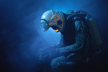 Spaceman or star trooper in the helmet and with rifle in the blue smoke. Science fiction concept.