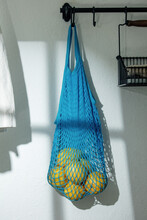 Blue Net Bag And Lemons In Kitchen