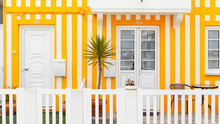 Vintage Beautiful Striped Yellow House With Doors, White Mailbox And Palm Tree On The Terrace