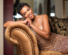Elegant African-American Woman With Short Stylish Hair Sitting On A Sofa