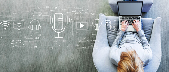 Wall Mural - Podcast theme with man using a laptop in a modern gray chair