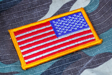 Fabric bent flag of Ukraine, UA. Blue and yellow colors. USA patch on army uniform. Stop the war. Patriotism. Ukraine concept. Democracy and politics. Close-up, background