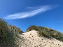 Sommerliche Dünenlandschaft An Der Nordseeküste Mit Sand Und Strandhafer Vor Blauem Himmel Mit Cyrruswolken Bei De Haan, Belgien