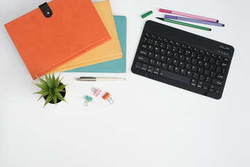 Wall Mural - Flat lay black to school and education concept on white table desk with key board computer and stack of book , stationeries and supplies, Top view with copy space, work space