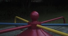 A HANDHELD CLOSE UP Of A Colorful Spinning Carousel, At An Empty Park At Dusk.  SLOW MOTION.