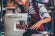© EKKAPON - Sewing process of the leather belt. Man's hands behind sewing. Leather workshop.