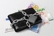 euro banknotes in a chain with a lock on the desk