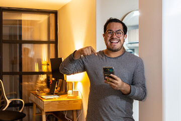 Programmer, web developer, designer working at office comparing mobile and desktop website versions Mexican latin holding phone