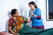 © WESTOCK - Nurse helping sick senior woman to stretch hand while doing routine exercise at home - concept of caregiver, physiotherapist and medical treatment