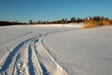 Wall Mural - Traces of vehicles and people on the frozen and snow-covered Volga River