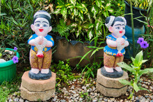Traditional Thai Garden Ornaments: Statuettes Of Smiling Girls In A Welcoming Pose
