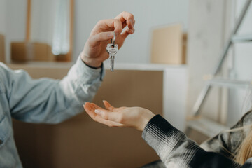 Happy young couple buying their new home and receiving keys from real estate agent, close-up