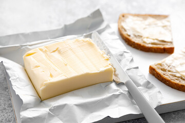 Sticker - Block of butter with butter knife in a open pack.  Buttering bread