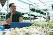 © Caia Image - Happy male garden shop owner talking on smart phone at laptop
