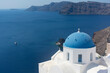 Santorini blue dome of white church in Oia with sea view and volcano, Greece landmark