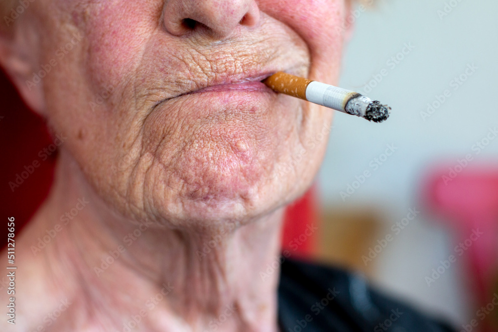 old lady smoking a cigarette close-up of an old woman smoking a cigarette Stock Photo