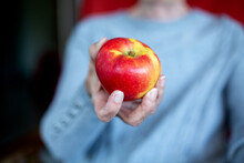 Close-up Of Older Woman Holding Red Apple