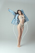 © Lustre Art Group  - Portrait of slim woman in underwear wear and shirt posing isolated over gray studio background. Lines around body before losing weight.