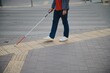 © Serhii - Blind Man Walking On Sidewalk Holding Stick
