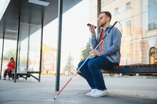 Blind Man With White Cane Waiting For Public Transport In City.