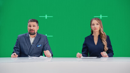 Newsroom TV Studio Live News Program: Caucasian Male and Female Presenters Reporting, Green Screen Chroma Key Screen Picture. Television Cable Channel Anchor Talks, Listens. Network Broadcast Mock-up