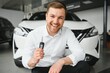 © Serhii - Man buying a car at a showroom