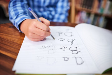 Sticker - Practising his handwriting. Shot of an unrecognisable young boy writing in a book at school.