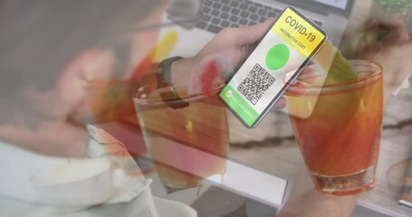 Sticker - Animation of drinks over hands of caucasian man holding smartphone with covid passport on screen