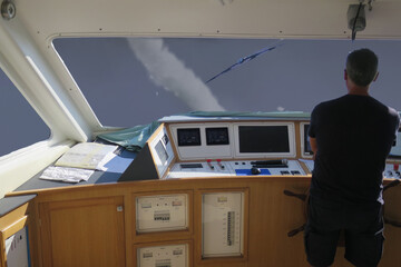 navigation cabin of boat with captain and stormy sky-