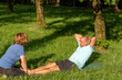 Man doing crunches with the help of his wife to be fit and healthy sorrounded by nature