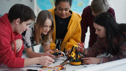 Wall Mural - group of students building and programming electric toys and robots at robotics classroom