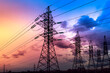 Silhouette of high-voltage electrical towers on a sunset background.