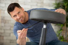 Man Adjusting Stool Chair At Home