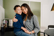 © Drobot Dean - Young beautiful asian mother with her son in cozy kitchen