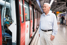 European Man Standing Beside Arrived Train In Subway Station.