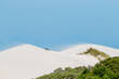 © Austockphoto - sand drifting on white dunes under blue sky