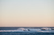 © Austockphoto - Long shot of breaking waves with spray and pastel sky