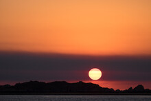 Glowing Orange Sunset With Hazy Sky Over The Rocky Shore Of The Kimberley Coast Western Australia